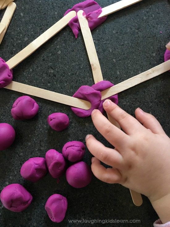 Craft sticks connected with purple play dough