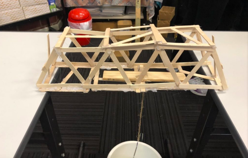 A student built bridge made from popsicle sticks across a couple of desks as an example of fun last day of school activities