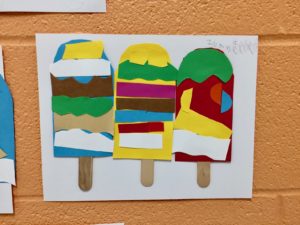 Three popsicles on white paper are constructed from strips of construction paper.