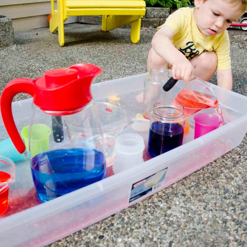 boy playing with jugs of water 