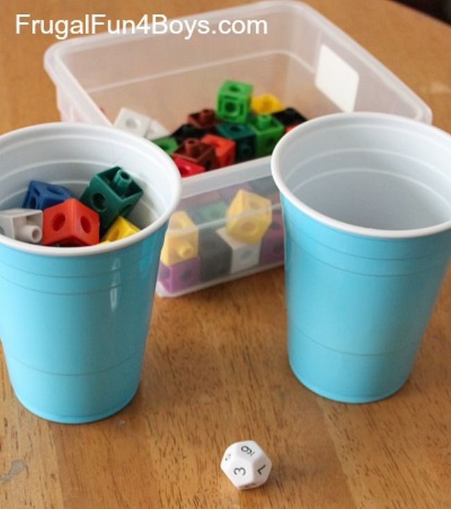 Two blue plastic cups with a bin of blocks and polyhedral die (Preschool Math Games)