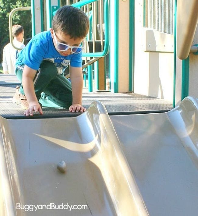 Preschool science student sending a rock down a playground slide