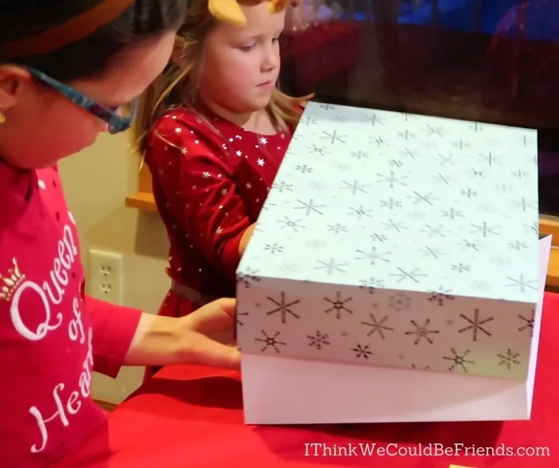 Two girls are shown unwrapping a gift in this example of minute to win it games.