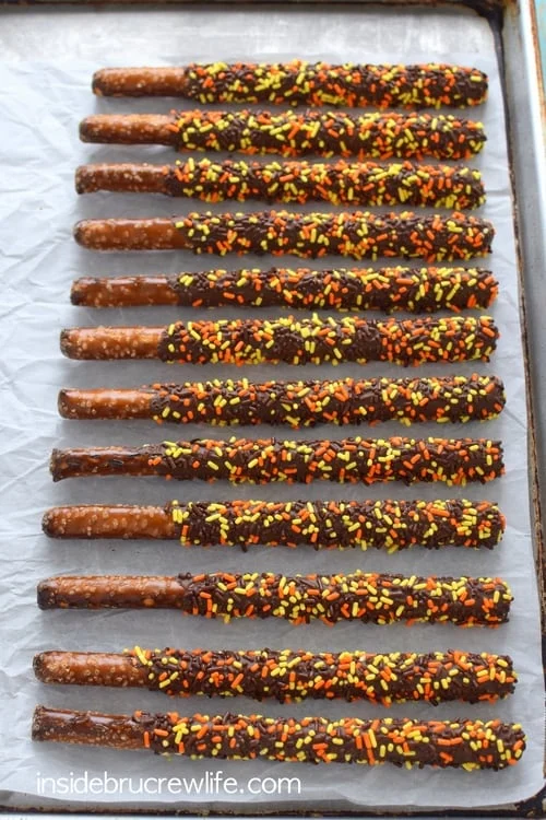 pretzels on a cookie sheet rolled in chocolate and sprinkles