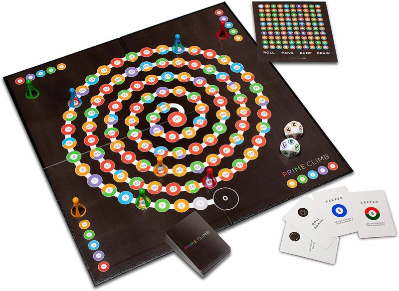 A black board game is shown spread out with a swirling path of colorful dots.