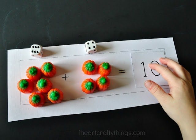 a math worksheet with candy pumpkins, dice and numbers