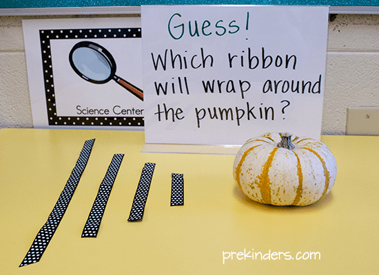 a tiny pumpkin with three lengths of ribbon next to it and a sign saying Guess which ribbon will wrap around the pumpkin