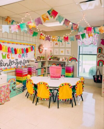 Colorful kindergarten classroom with pom pom chairs, banners, and garland