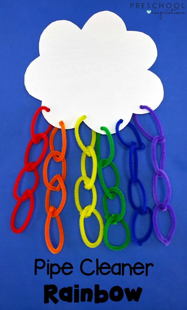 A white cloud has holes cut in the bottom that have interlocking loops of different colored pipe cleaners coming out of it.