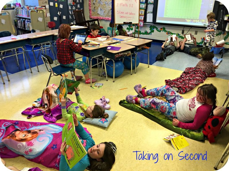 Students lying on blankets on the floor of a classroom reading