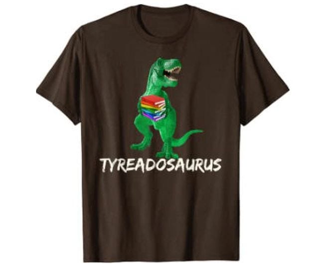 Brown t-shirt with picture of a dinosaur holding a book reading Tyreadosaurus