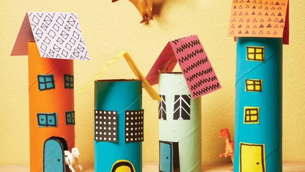Paper towel rolls and other pieces of paper are used to make brightly colored buildings and houses.