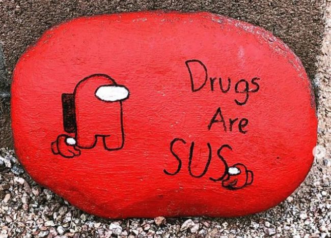 Small rock painted red saying "Drugs are SUS"