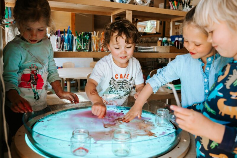 Reggio Emilia preschool students engaging in light and water play.