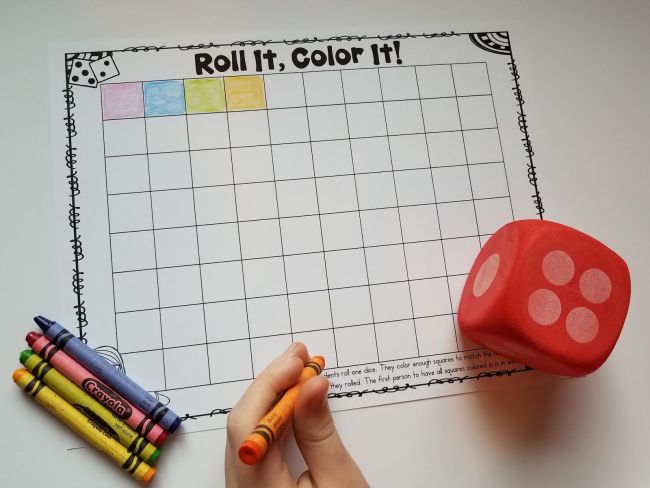 Child holding an orange crayon and preparing to color several squares on a worksheet to match the number of dots on the dice