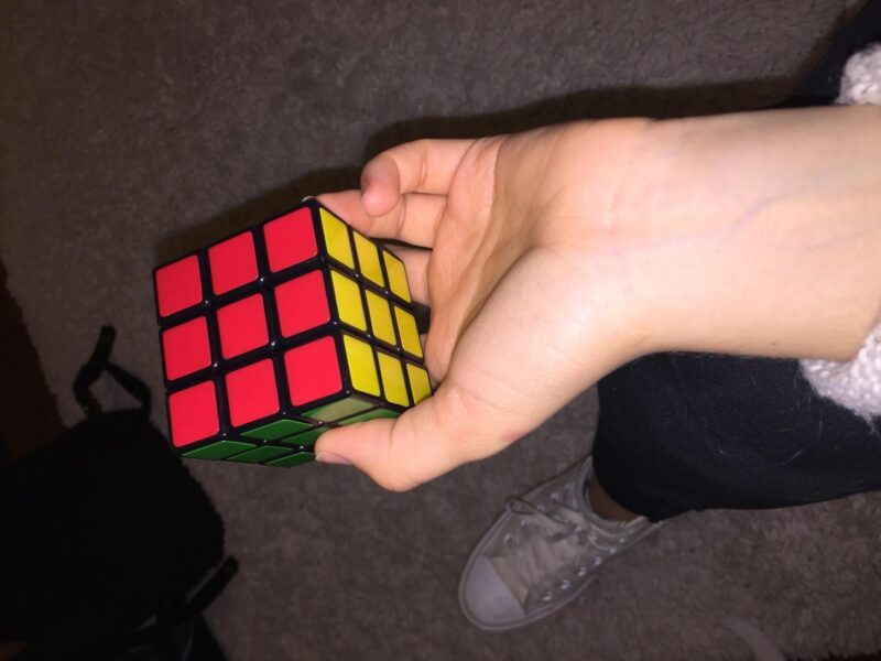Middle school student's hand holding a Rubix cube.