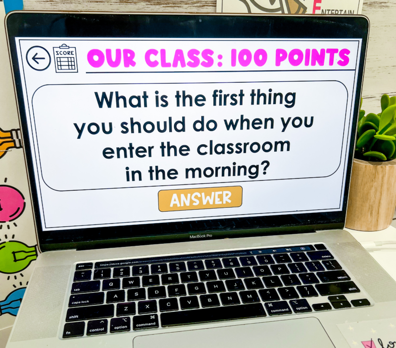 Classroom Management Game: Rules Bingo Laptop screen showing a slide with a question from a rules and routines trivia classroom management game