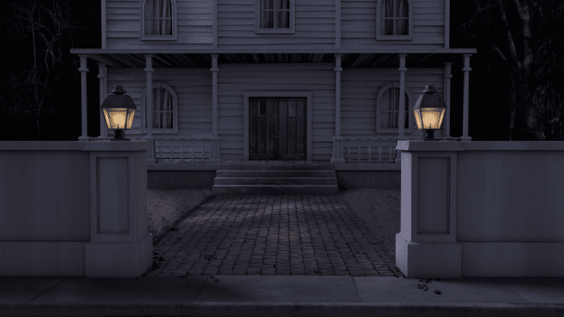 Spooky house at night with two lamps on the wall surrounding the house lighting the walkway to the front door