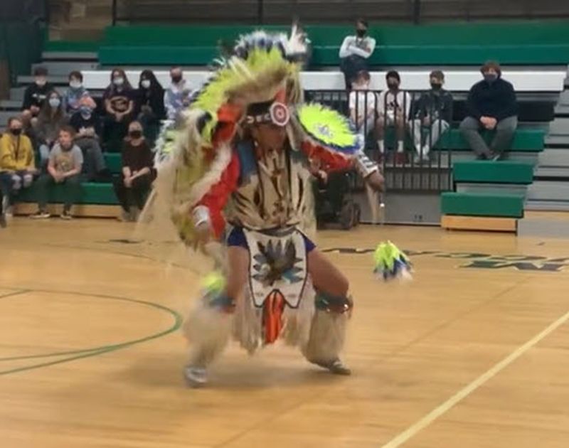Indigenous dancer performing at a school assembly
