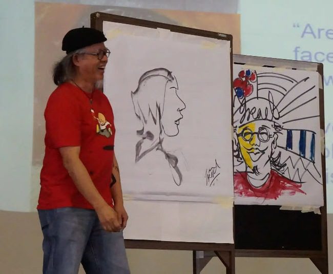 Artist displaying his work at a school assembly