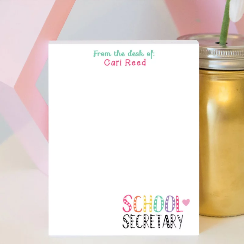 Personalized school secretary notepad next to a gold tumbler with straw.