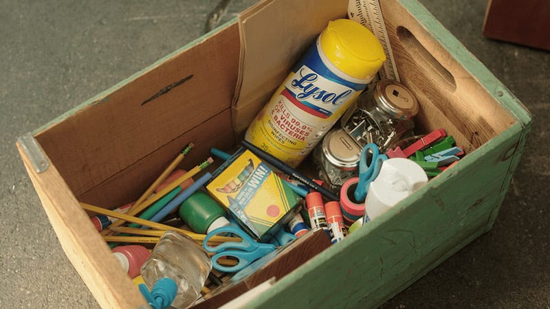 Wooden box with school supplies including Lysol Wipes and crayons