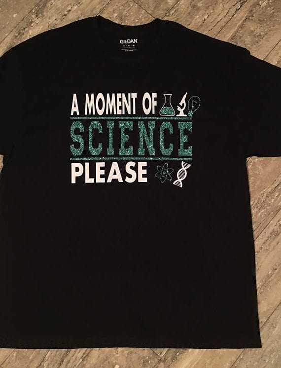 "A moment of science please" black teacher tshirt with science symbols.
