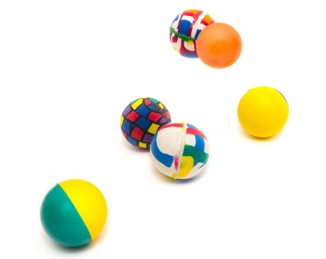Colorful rubber balls bouncing against a white background