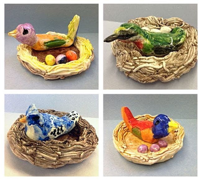 Clay birds in clay nests with eggs