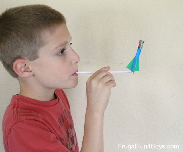 Student blowing on a drinking straw to launch a tiny rocket