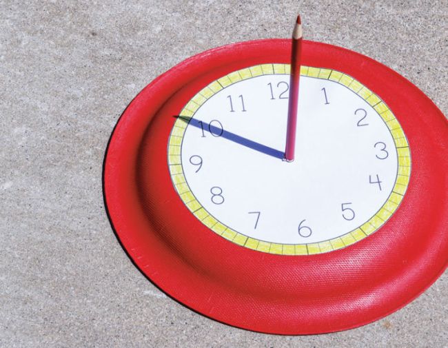 DIY sundial made from a paper plate and a pencil, as used in a second grade science experiment.