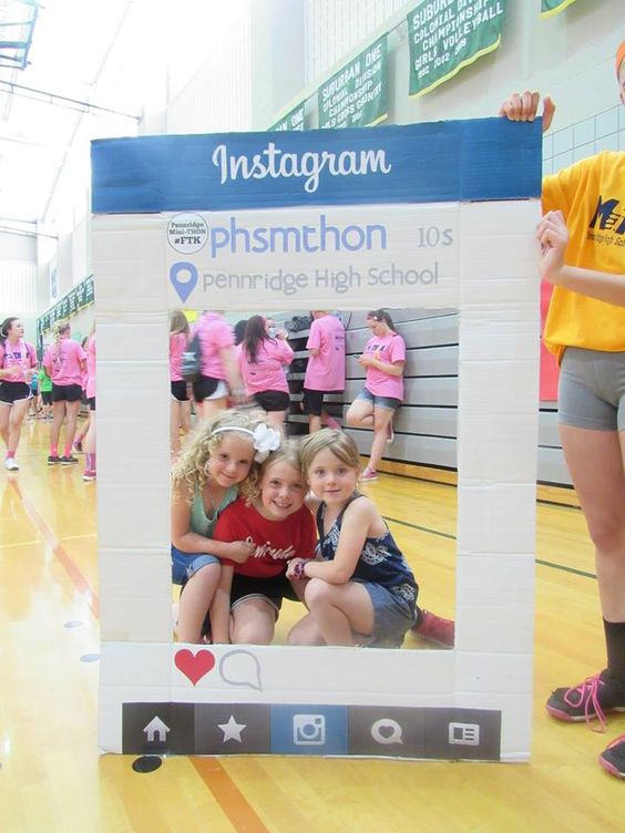 Students peek through a selfie display at a pep rally