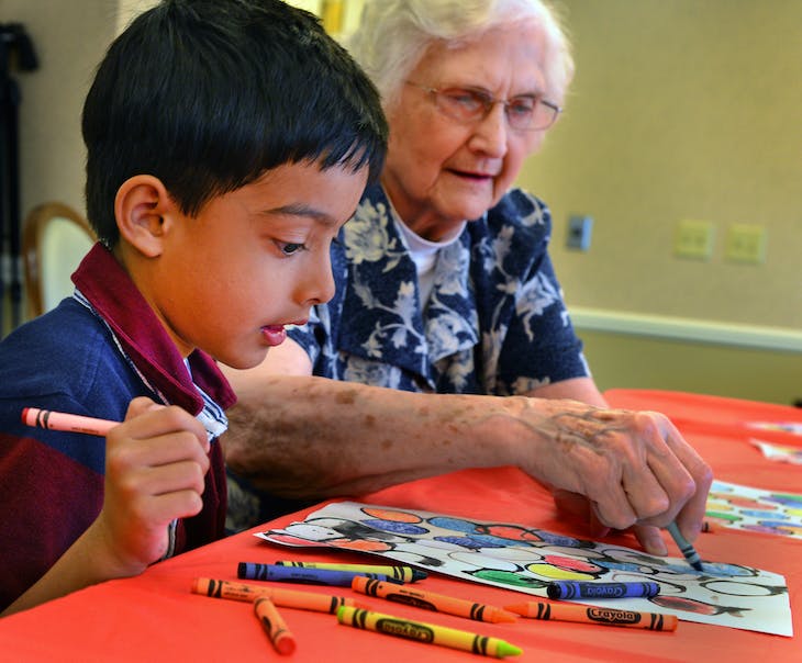 Child and senior citizen working on an art project together (Service Learning Projects)