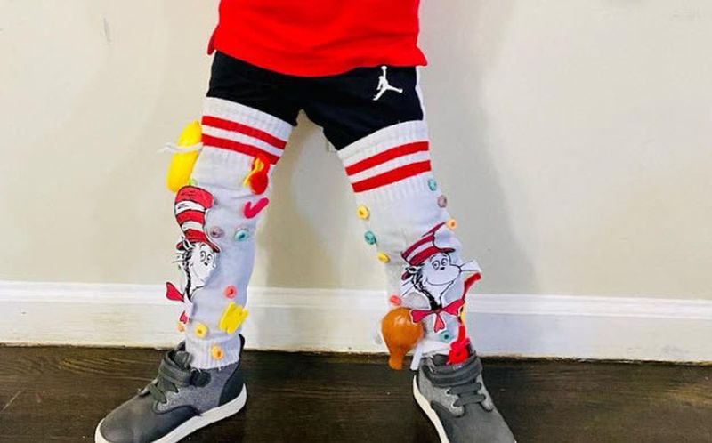 Child wearing socks decorated with the Cat in the Hat theme