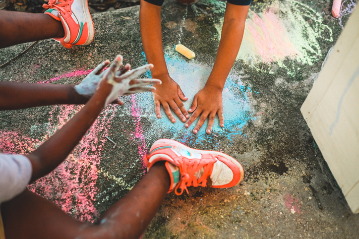 Students outside drawing with sidewalk chalk