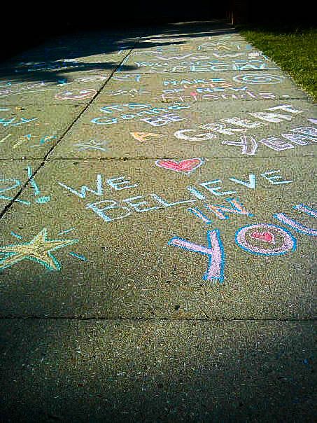 Encouraging messages written with sidewalk chalk on the pavement