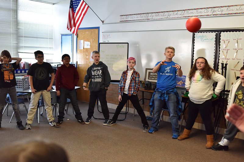 Kids standing in a circle tossing a ball around as an example of indoor recess games and activities