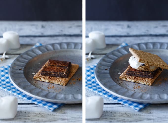 S'mores on a silver plate with a blue and white checkered napkin on a picnic table.