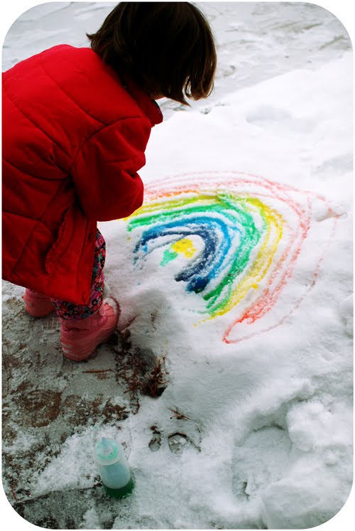 girl using a spray bottle and coloring to paint snow 
