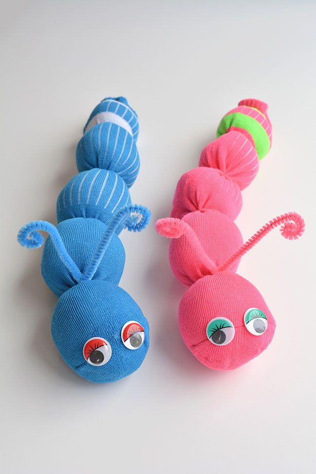 Two stuffed worms- one pink and one blue- sit side by side