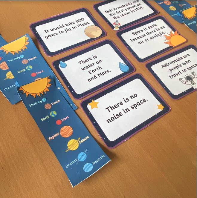 Printable solar system fact cards and bookmarks on a desk.