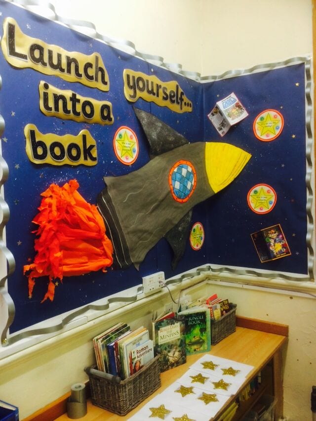 Classroom library corner decorated with dark blue walls and space theme