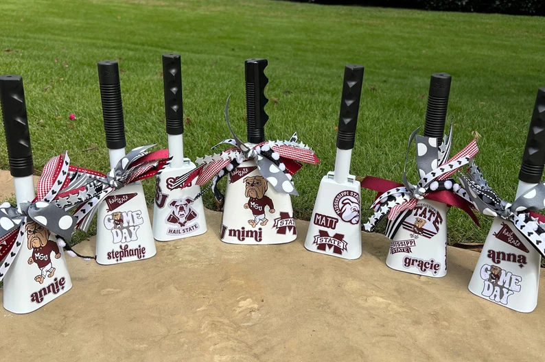 A line of cowbells decorated with ribbons and school colors