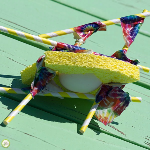 an egg covered in a sponge and reinforced with straws and tape for an egg drop challenge idea