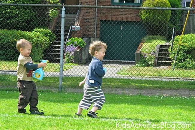 boy spraying another boy with a spray bottle 