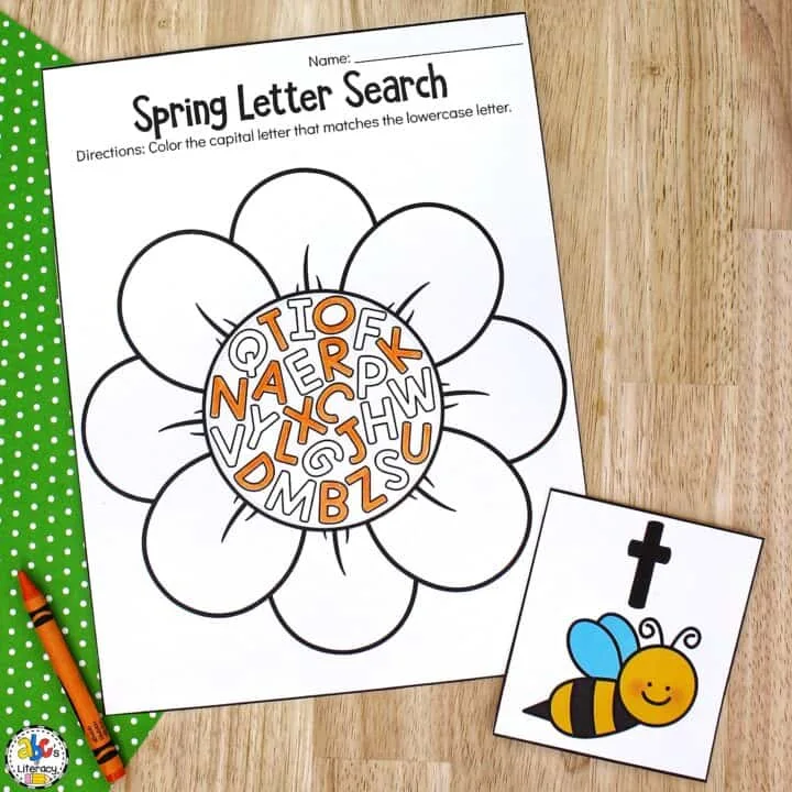 A printout of a large flower with letters written in the center is flanked by a letter card with a picture of a bee and a lowercase t