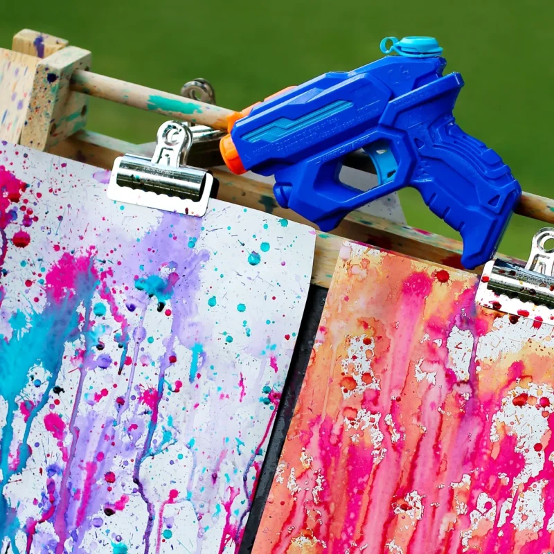 squirt gun and papers with paint 