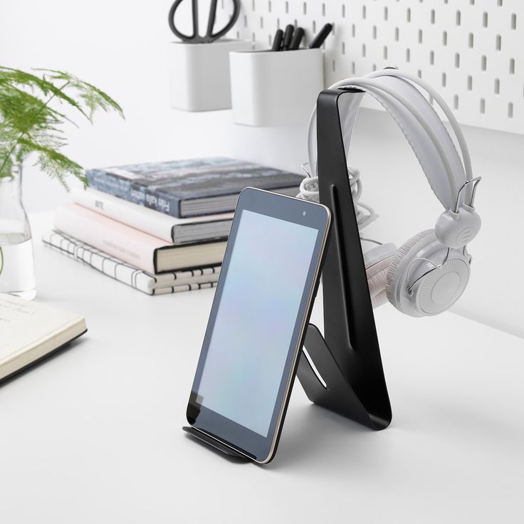 A tablet stand has a tablet on it and headphones 
