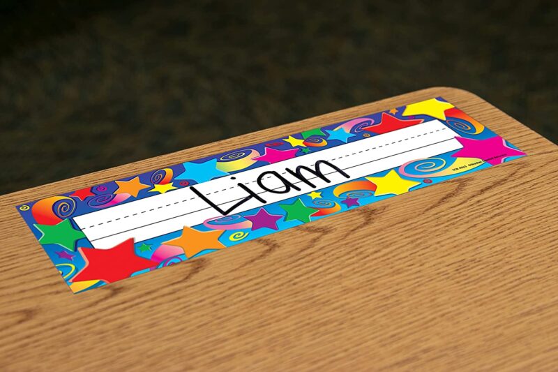 Space-themed classroom star name plate with "Liam" written on it on a student desk
