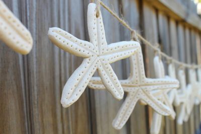white clay starfish strung together along a fence